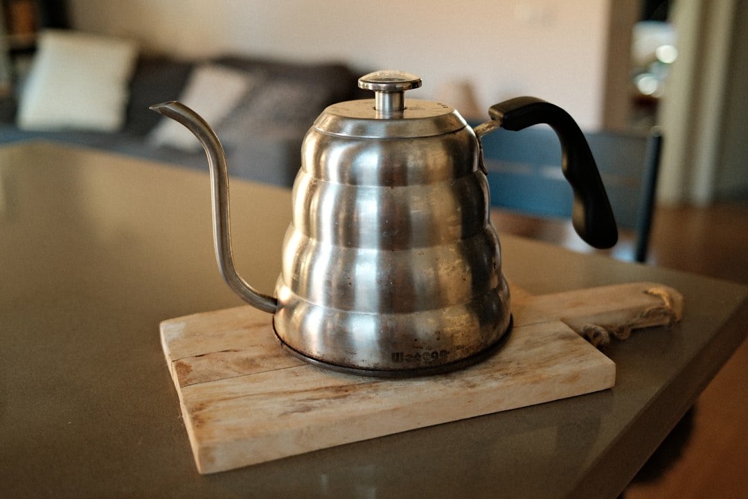a-stainless-steel-gooseneck-kettle-on-a-wooden-board-bd3z3bq9m4c